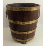 A 19th century coopered oak, brass banded bucket, with lion's mask handles and paw feet