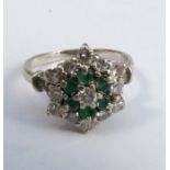 A diamond and emerald cluster ring, the white mount stamped '18ct', the thirteen diamonds