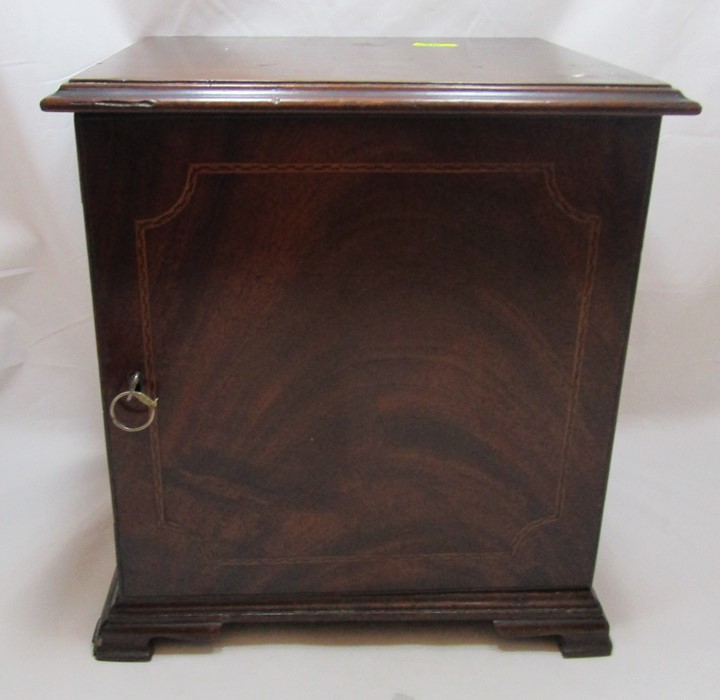 A 19th century mahogany coin cabinet, having a single door opening to reveal nine trays, with