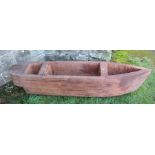 A carved wooden planter, formed as a boat, length 59ins, height 12.5ins