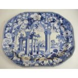 A 19th century English blue and white transfer printed meat plate, decorated with classical ruins to