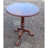 A mahogany tripod table, with carved edge, raised on a bird cage to a carved column and three