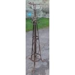 An Arts and Crafts style wrought iron and steel oil lamp stand, decorated with scrolls and rings,