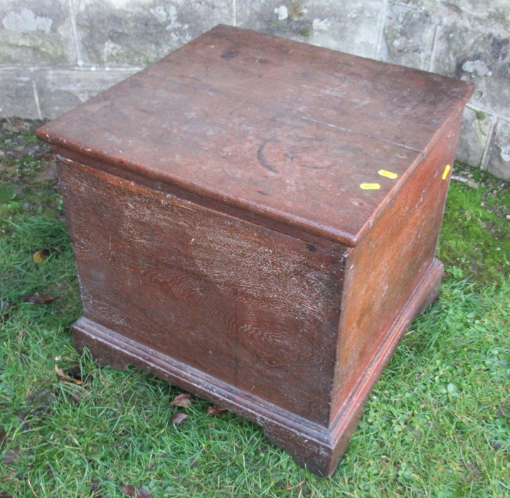 An oak box, with hinged rising lid, raised on bracket feet, 19.75ins x 19ins, height 19ins