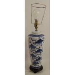 A porcelain table lamp, decorated in blue and white with Oriental fish, on a wooden base, height