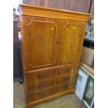 A modern yew veneered cabinet, the upper section with a pair of cupboard doors, the base with a pair