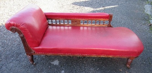 An Edwardian mahogany showwood chaise lounge, with scroll arm and gallery rail, carved decoration