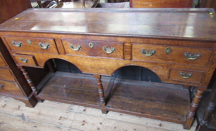 An Antique oak dresser base, fitted with three drawers over two small drawers, with arches to the