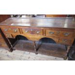 An Antique oak dresser base, fitted with three drawers over two small drawers, with arches to the
