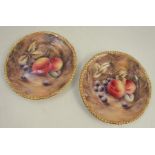 A pair of Royal Worcester plates, decorated with fruit to a mossy background by P Love, dated