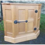 A Robert Mouseman Thompson oak corner unit, the door with four fielded panels and fielded sides, on