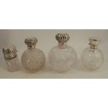 Four hallmarked silver mounted glass dressing table bottles, three with circular bases, the other