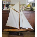 A model pond yacht, with sails on a mahogany base, length 38ins x  height 39ins