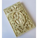 A Cantonese ivory card case, carved with a panel of a pair of oriental figures, and all over with