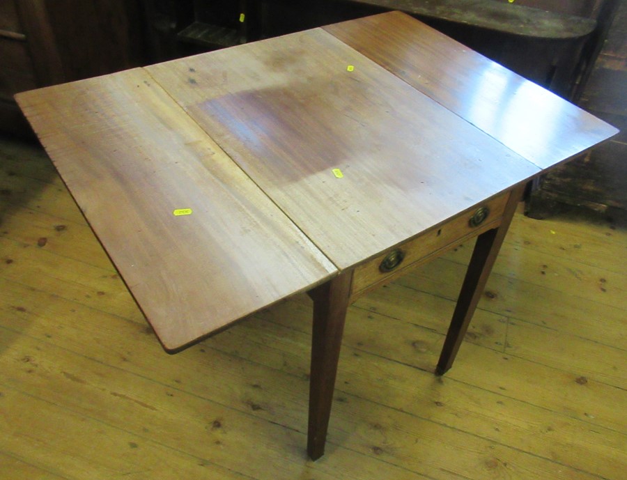 A mahogany Pembroke table, with drop leaves and fitted with one real and one dummy drawer, raised on