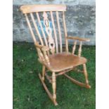 A modern elm Windsor rocking chair, with pierced splat back, the underside of the seat carved with a