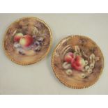 A pair of Royal Worcester plates, decorated with fruit to a mossy background by P Love, dated