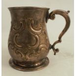 A Georgian silver pint mug, of baluster form with embossed decoration, London 1750, weight