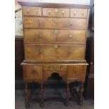 An Antique walnut chest on stand, the chest fitted with three short drawers over three graduated