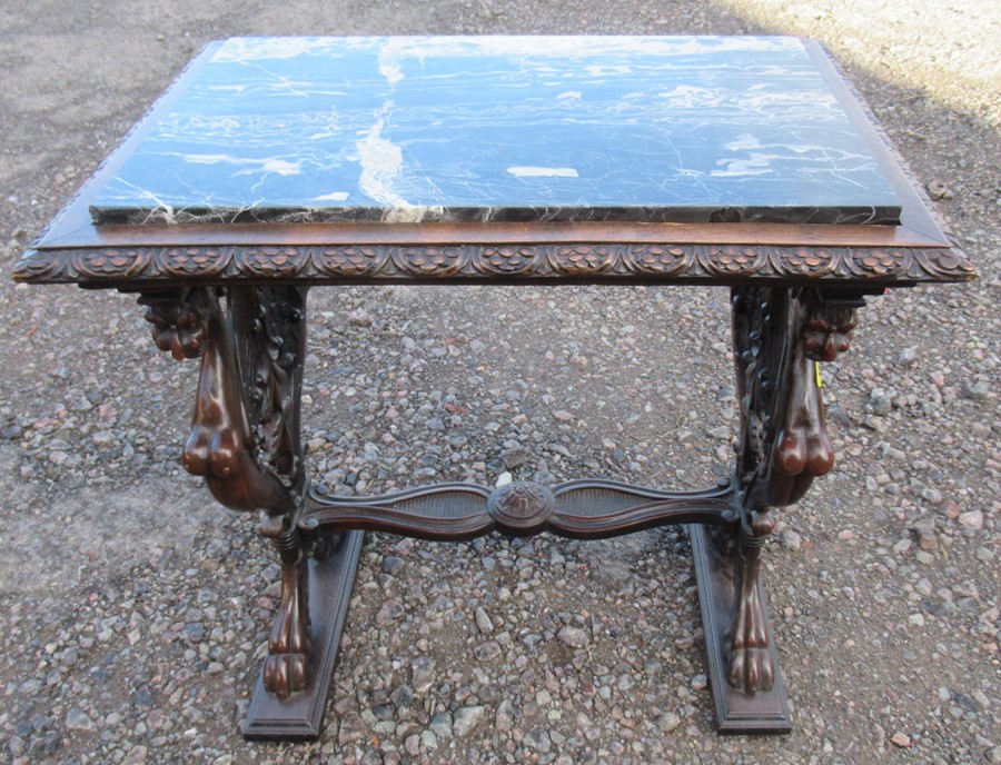 A marble topped mahogany table, the rectangular marble set in to a carved frame, raised on end