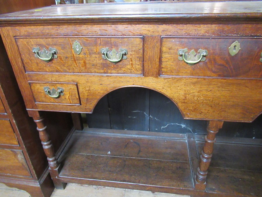 An Antique oak dresser base, fitted with three drawers over two small drawers, with arches to the - Image 2 of 3