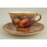 A Royal Worcester cup and saucer, decorated with fruit to a mossy background by P Love, dated