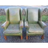 A pair of wing armchairs, upholstered in green leatherette, on fluted square legs