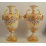 A pair of Royal Worcester blush ivory vases, decorated with flowers and blue trailing flowers,