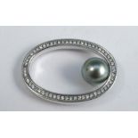 An 18 carat white gold black cultured pearl and diamond pendant, the open oval set with sixty