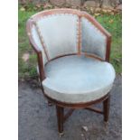 A mahogany framed and leatherette upholstered revolving office chair, raised on four legs united