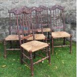 A set of six oak dining chairs, with carved top rail over spindles with rush seat