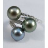 A three stone grey cultured pearl and diamond ring, the white mount stamped '750', the pearls of