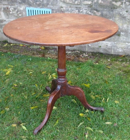 An Antique mahogany tripod table, with tilt top, raised on a turned column and three outswept