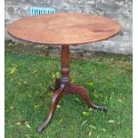 An Antique mahogany tripod table, with tilt top, raised on a turned column and three outswept