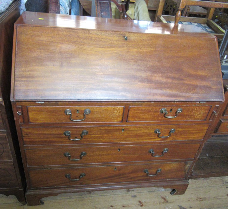 A 19th century mahogany bureau, the interior fitted with drawers and pigeon holes, over two short