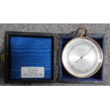 A brass cased compensated pocket pressure gauge, with silvered dial, in a leather covered case