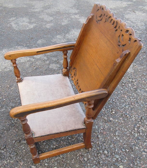 An oak monks seat, with pierced decoration to the slide top, upholstered seat, with plaque to