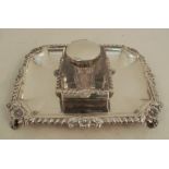 A silver desk stand, of rectangular form with gadrooned edge and flowers, set with a square glass