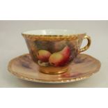 A Royal Worcester cup and saucer, decorated with fruit to a mossy background by P Love, dated 1952/