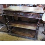 An oak three tier oak buffet, with carved decoration, fitted with one long drawer over shelves