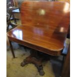 A 19th century mahogany fold over tea table, raised on a shaped column to a shaped platform, to