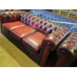 A Three Seater Chesterfield in oxblood leather upholstery