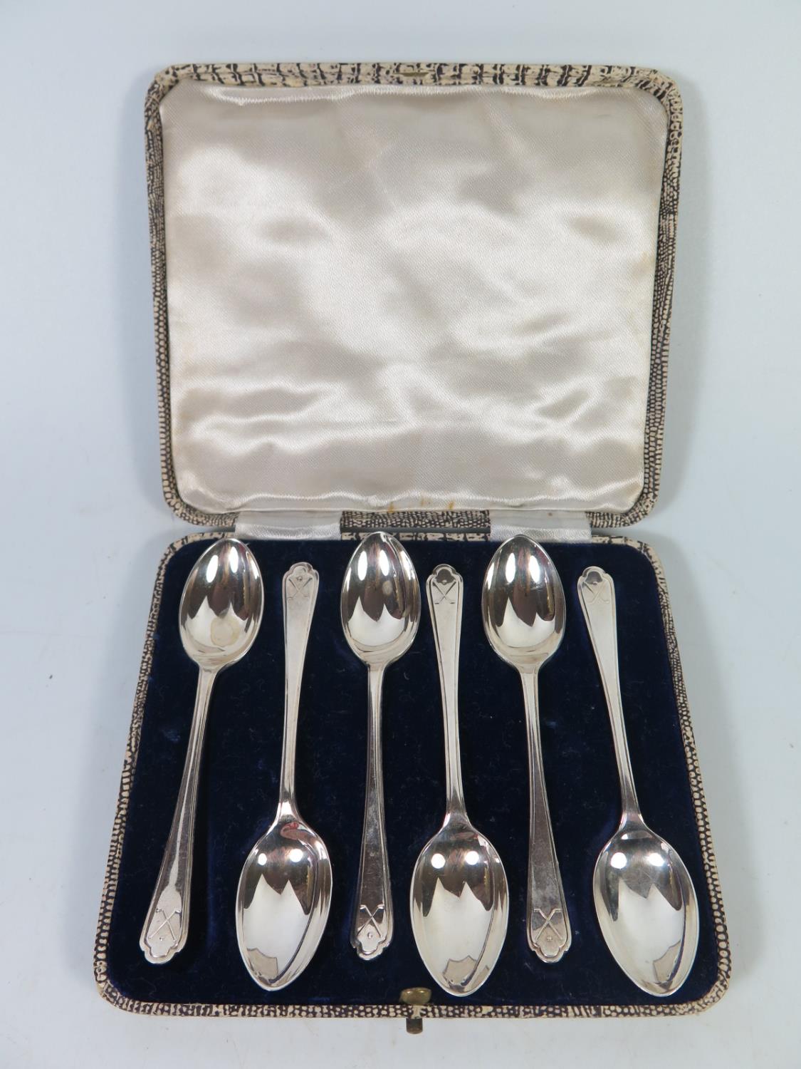 A Cased Set of George V Silver Teaspoons with crossed golf club emblem to handle, Sheffield 1933,