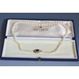 A Pearl Necklace with a 9ct gold garnet set clasp, 52cm, 28.1g and in a Mappin & Webb box