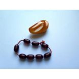 A Baltic Amber Brooch 48x27mm 10.4g and faux cherry amber beads 8.6g