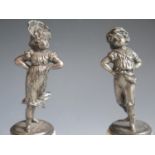 A Pair of Cast White Metal Figurines of a Girl and Boy on alabaster bases, girl 14.5cm high