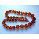 A Graduated Faceted Faux Orange Amber Bead Necklace, 67cm, 83.7g