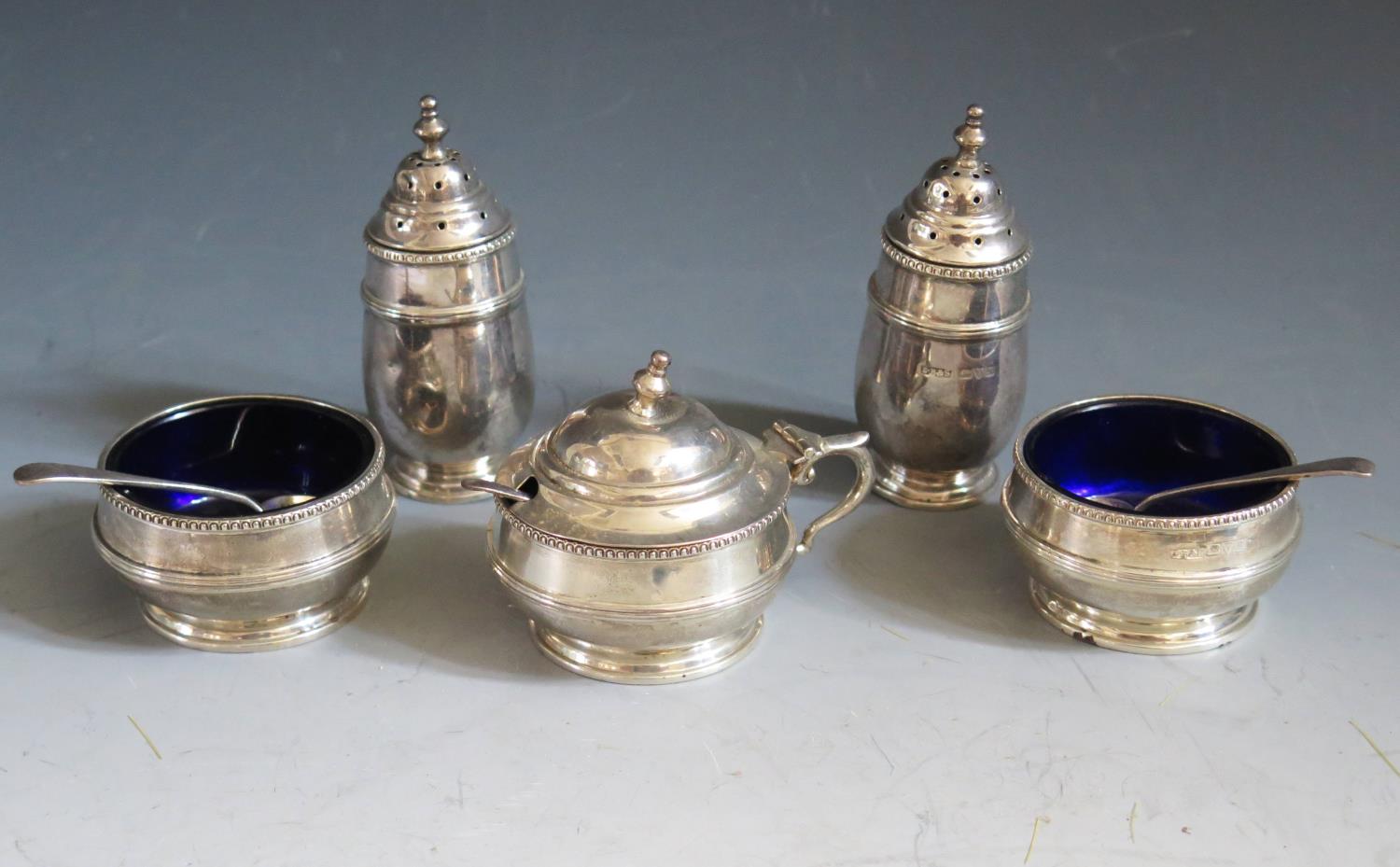 A George V Silver Five Part Cruet Set with blue glass liners (and three matched spoons), Chester