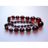 A Graduated Faceted Faux Cherry Amber Bead Necklace, 58cm, 65.3g