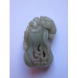 A Chinese Carved and Pierced Jade decorated as a gourd with surmounted by a scaled beast and with